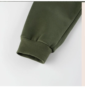 Gros plan des poignets côtelés vert militaire sur un pantalon en coton polaire