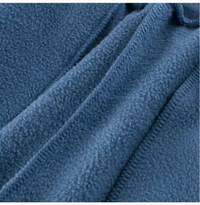 Vista macro de forro polar azul marino con costuras de borde limpias y detalladas