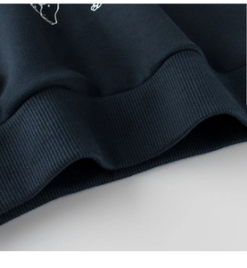 Detailed close-up of the ribbed knit hem and soft fabric on a dark blue kids' hoodie