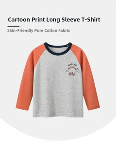 Détail d'un t-shirt à manches raglan en coton avec imprimé dinosaure sur la poitrine