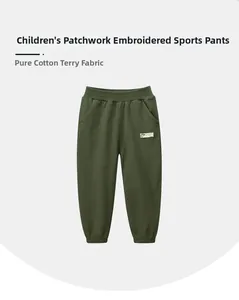 Detail of army green cotton joggers with elastic waist and white ARMY patch embroidery