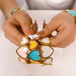 Dettaglio del bracciale a cuore in smalto colorato con maglie flessibili placcate oro