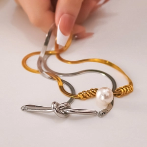 Collier nœud plaqué or 18 carats avec perles montré sous un angle de 45 degrés