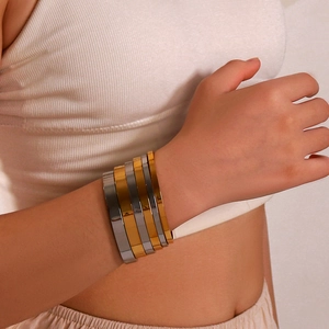 Minimalist 18K gold and silver plated stainless steel bangles set worn by a model