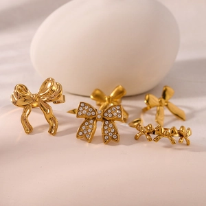 Golden bow knot ring set with cubic zirconia and pearls in polished stainless steel