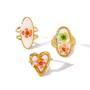 Anelli regolabili in acciaio dorato con veri fiori secchi colorati in resina