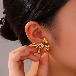Large gold bow earrings with crystal inlay shown on a model for a stylish look