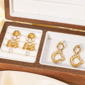 Orecchini a fiocco in oro 18k con perle presentati in un'elegante scatola di legno