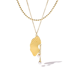 Détail du collier double rang doré avec pendentif en forme d'éventail et perles blanches