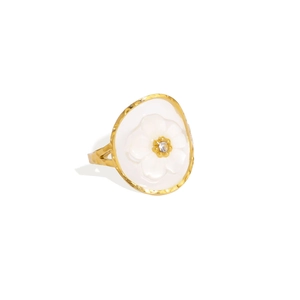 Détail de la bague martelée dorée avec fleur blanche et cristal étincelant au centre