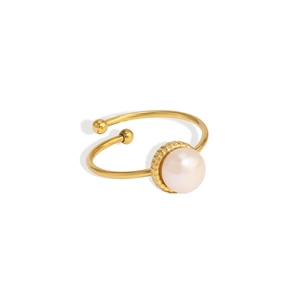Détail d'une bague ajustable dorée ornée d'une perle blanche et de sphères en métal
