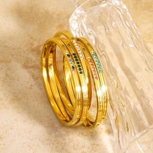 Luxurious gold stainless steel bangles set with colorful rhinestones in a modern four-piece stack
