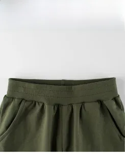 Detailed close-up of olive green kids sports pants with elastic ribbed waistband