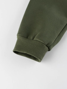 Gros plan sur les poignets de jogging en polaire vert olive avec tricot côtelé soigné