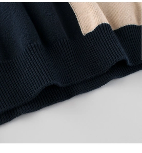 Détail du bord côtelé d'un pull en maille bicolore bleu marine et beige pour enfant