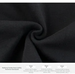 Close-up of black cotton knit fabric texture with textile safety classification labels