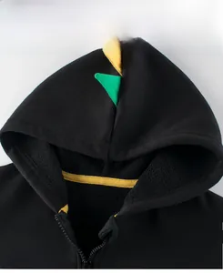 Detail view of children's dinosaur hoodie with yellow spikes and warm fleece lining
