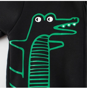 Close-up of black cotton hoodie featuring a green cartoon crocodile print for kids