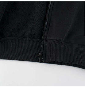 Close-up of kids black zipper jacket featuring ribbed hem and warm fleece lining