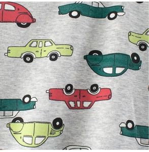 Close-up of soft grey knit cotton fabric featuring colorful vintage car print patterns