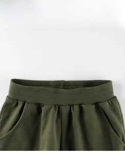 Detail view of army green cotton sports pants with elastic waistband and side pocket
