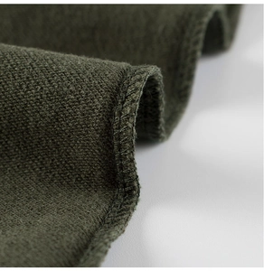Macro detail of dark olive cotton knit joggers showing premium stitching and fabric texture