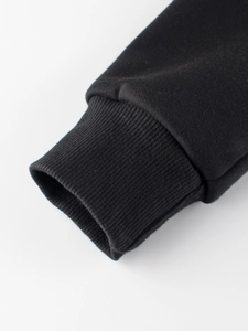 Kids black zip-up hoodie featuring detailed knitted ribbed cuffs and thick cotton fabric