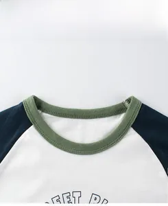 Dettaglio del girocollo bicolore con costine verde oliva e maniche raglan su maglia in cotone