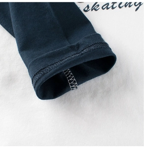 Dettaglio dei polsini a doppio ago e cuciture lockstitch su una maglia in cotone