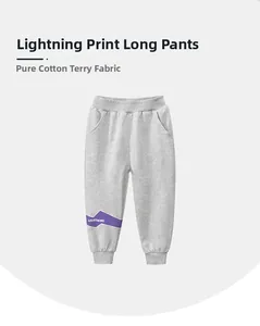 Detailed texture of cotton joggers with lightning print and elastic waistband for boys