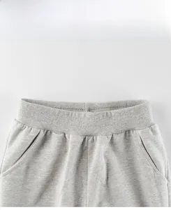 Detail view of children's grey sports trousers featuring elastic waistband and knit fabric