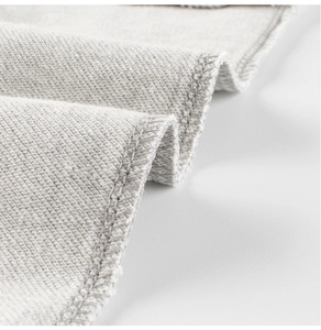 Close-up of high-quality grey knit fabric with professional overlock stitching detail