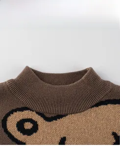 Detail showing the brown knit sweater's ribbed mock neck and cute bear pattern