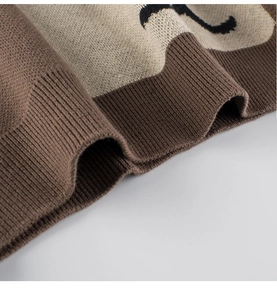 Close-up of soft brown knit teddy bear sweater with detailed ribbed cuffs for toddlers