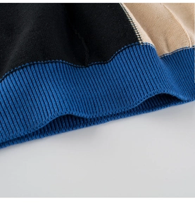 Detail der weichen Rippstrickbündchen mit schwarzen, beige und blauen Farbblöcken