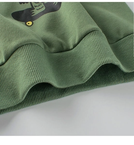 Detalle de dobladillo acanalado verde militar y estampado de skate en sudadera