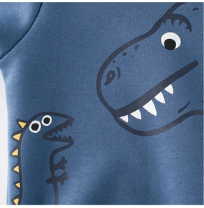 Detailaufnahme des blaugrünen Strickstoffs mit süßem Dinosaurier-Aufdruck für Kinder