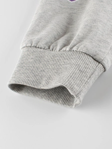 Close-up of heather grey kids sports trousers featuring durable ribbed ankle cuffs