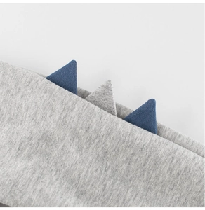 Close-up of grey sweatshirt fabric with 3D blue and grey dinosaur spine details