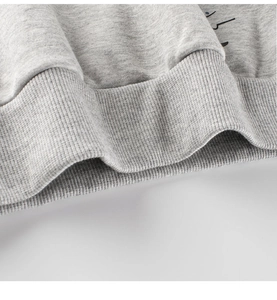 Macro detail of ribbed hem and knit texture on children's dinosaur marl grey sweatshirt