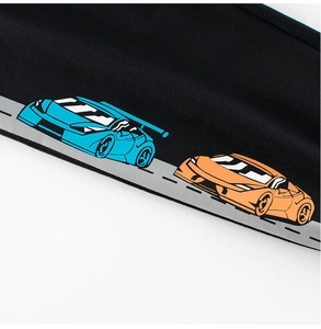 Gros plan du pantalon de sport enfant avec motifs de voitures de course bleu et orange