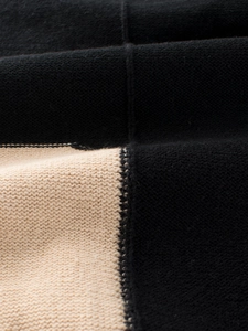 Nahaufnahme von Jungen-Strickpullover mit schwarz-beigem Kontrast und weicher Textur