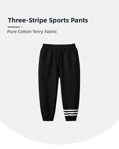 Detail of kids black cotton French terry joggers with white triple stripes on the cuff
