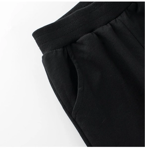 Detail of kids black sports joggers featuring a ribbed elastic waistband and side pockets