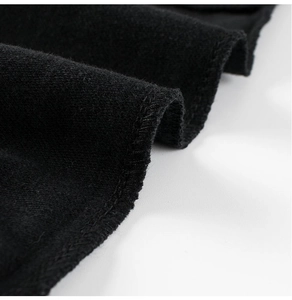 Macro shot of durable hem stitching on soft black thermal fleece fabric for kids' joggers