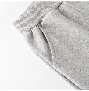 Dettaglio ravvicinato di pantaloni sportivi grigio chiaro per bambini con vita elastica