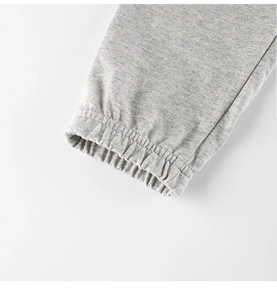 Dettaglio dei polsini a costine in cotone grigio melange sui pantaloni sportivi bimbo