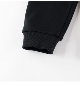 Detail van geribbelde manchetten op zwarte joggingbroek met hoogwaardige stoftextuur