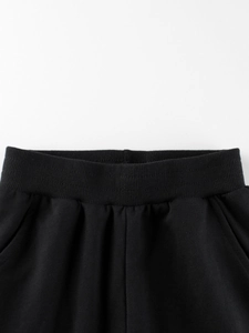 Close-up of boys' black cotton sports trousers featuring a ribbed elastic waistband