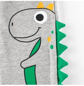 Détail du pantalon en maille pour garçon avec motif dinosaure et bords 3D verts